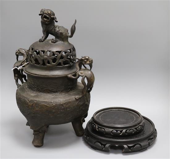 A large Chinese bronze tripod censer and cover and two wood stands censer height 42cm